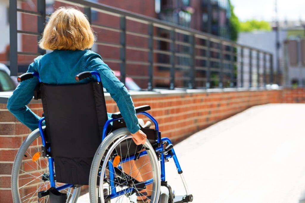 Image of a woman in a wheelchair entering a ramp or platform